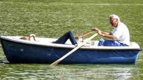 Un jubilado rema en una pequeña barca en un estanque