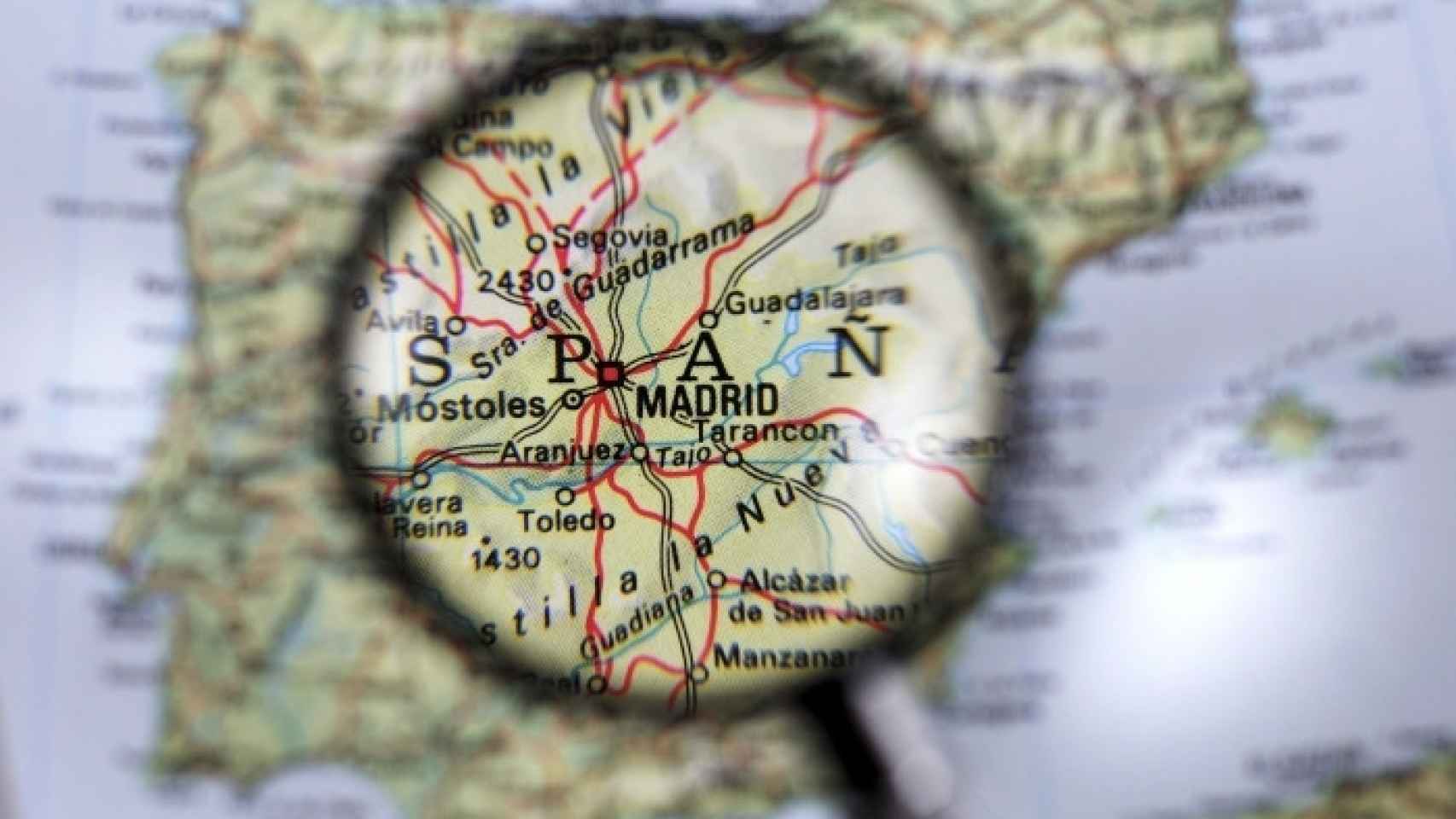 Una lupa enfoca un mapa de España / CG