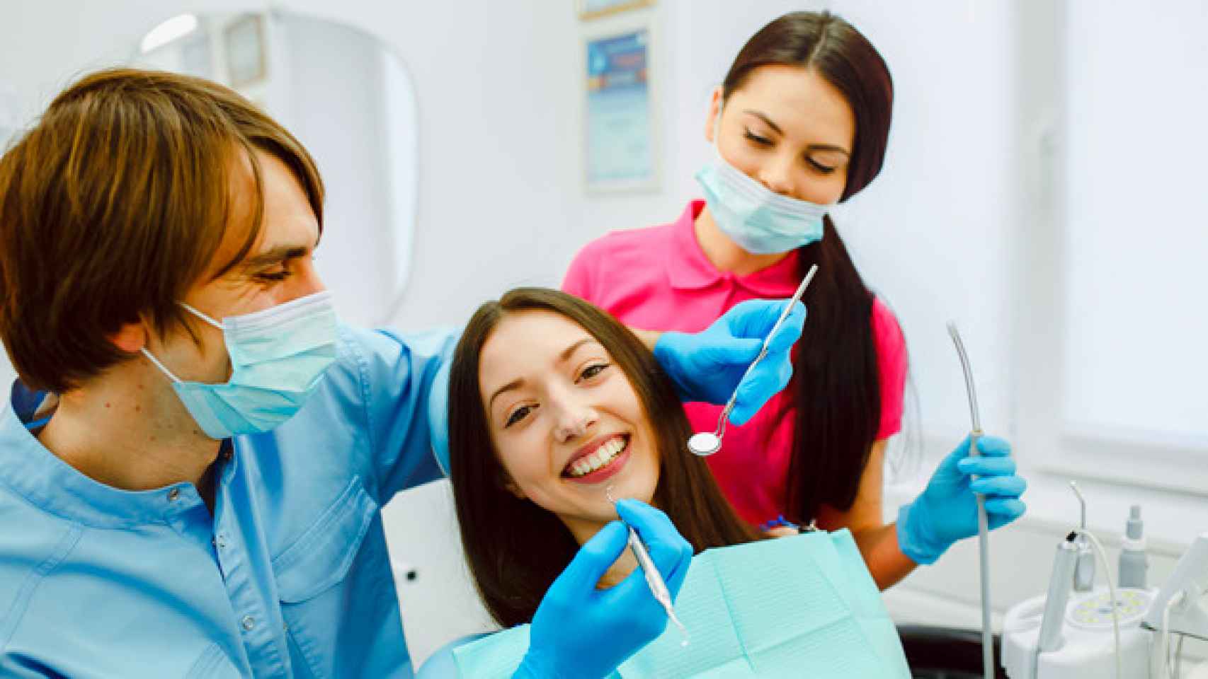 Dentista examinando las dientes de una paciente / CG