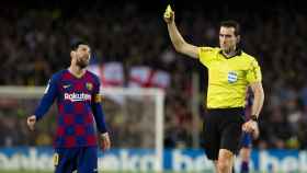 Martínez Munuera mostrando la amarilla a Leo Messi / EFE