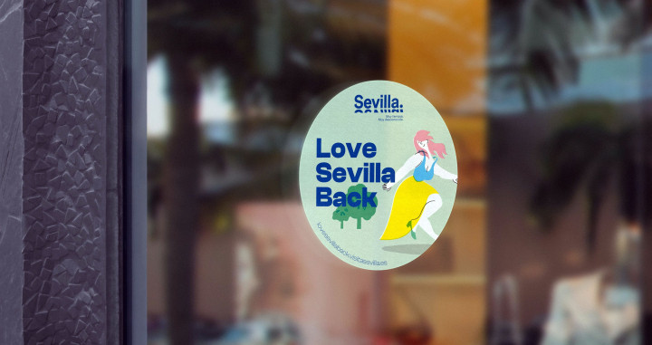 Pegatina con el lema ‘Love Sevilla Back’ en la puerta de un establecimiento / VUELING