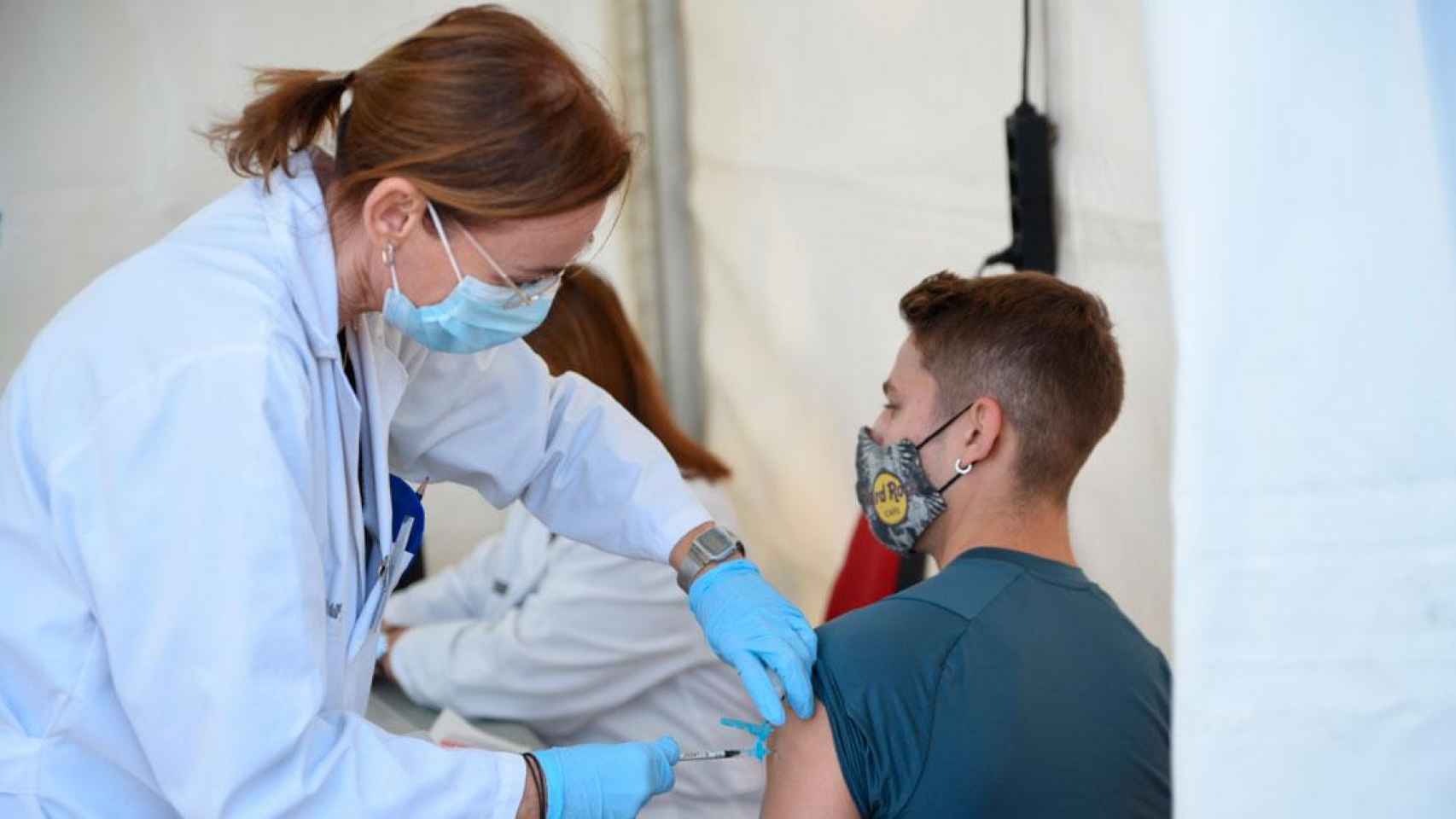 Una sanitaria administrando una vacuna contra el Covid-19 a un joven en Valencia / EP