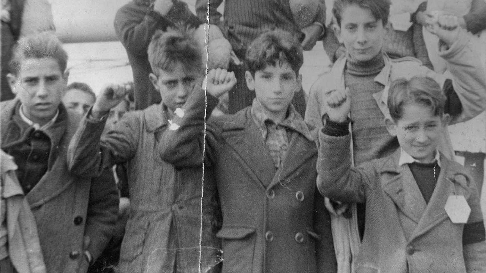 Un grupo de niños saludan a la cámara haciendo el signo republicano antes de ser evacuados tras la derrota en la Guerra Civil (1939) de esa España peregrina / CG