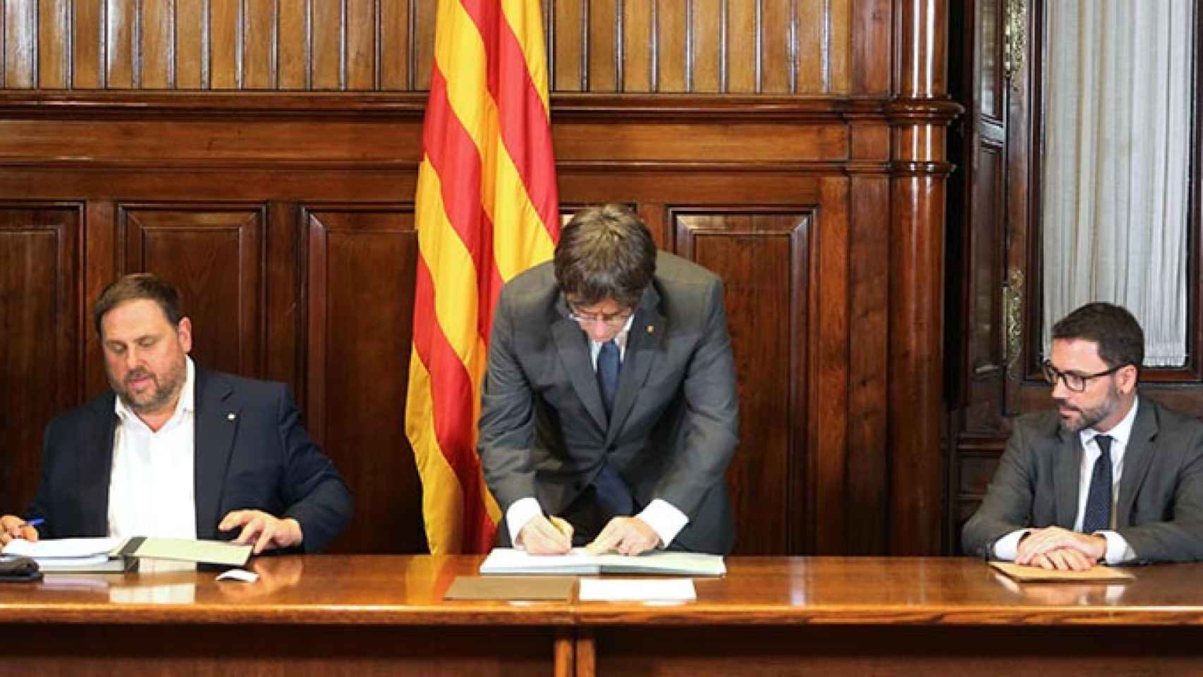Campaña: El presidente de la Generalitat, Carles Puigdemont, firma el decreto de convocatoria del referéndum junto al vicepresidente Oriol Junqueras y el secretario del Govern / RUBEN MORENO