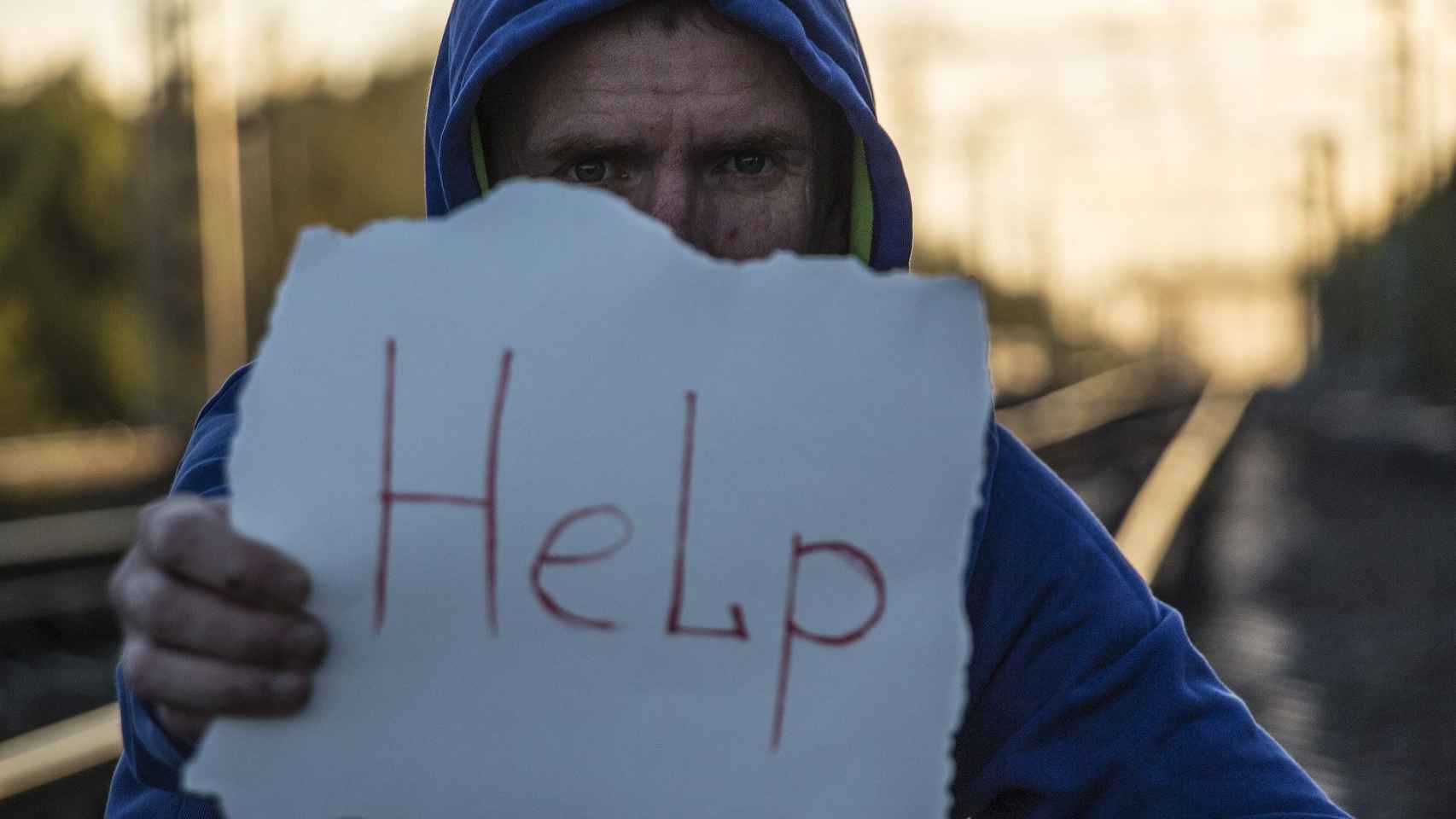 Un hombre con un cartel en el que pide ayuda contra los suicidios / PIXABAY