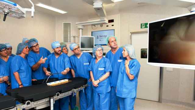 El consejero de Salud, Toni Comín, manipulando aparataje, junto a la alcaldesa de L'Hospitalet, Núria Marín (4i) y la gerencia de Bellvitge / CG