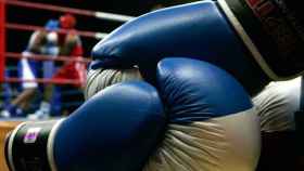 Un combate de boxeo, con un par de guantes en primer plano / CG