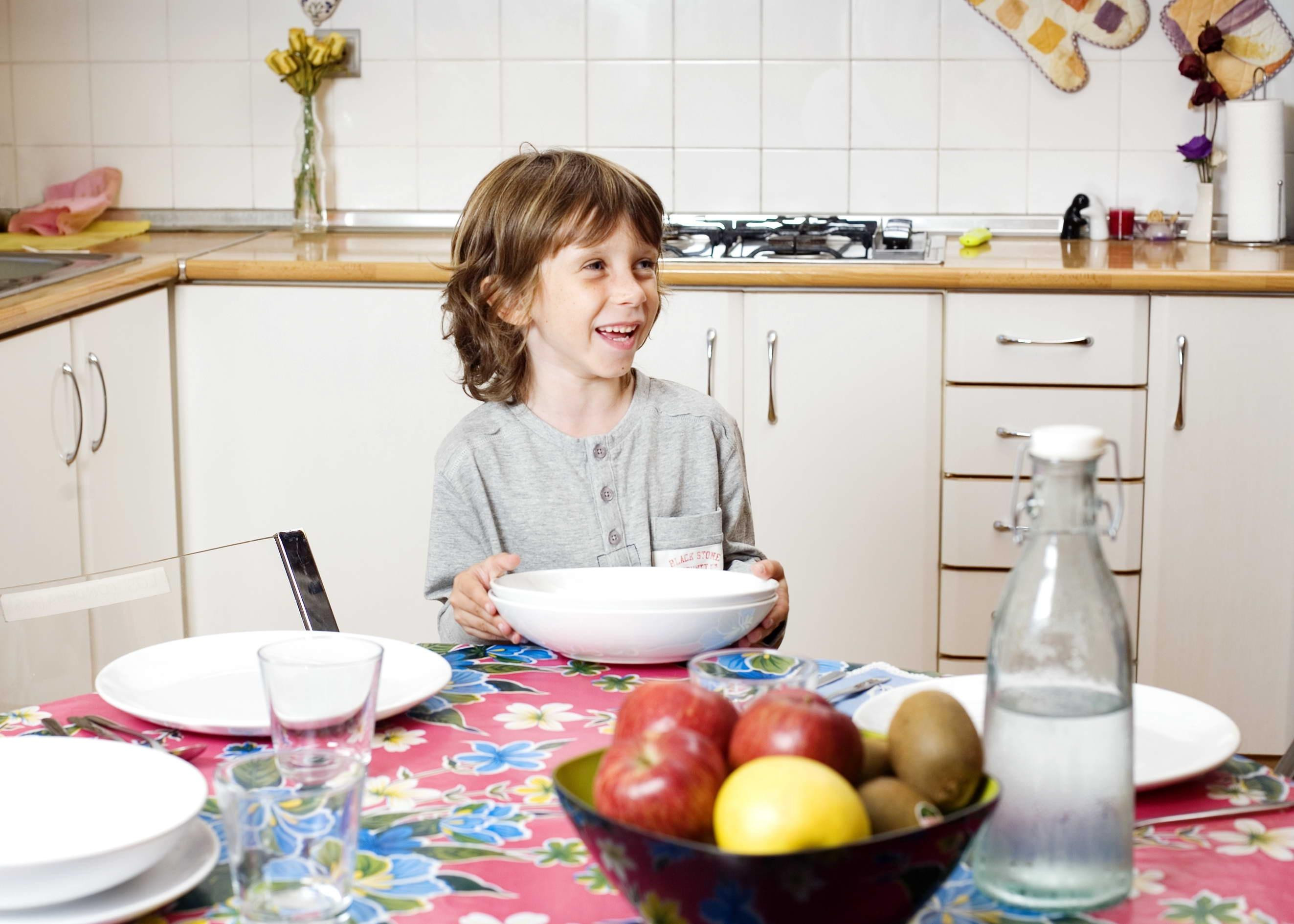 Un niño que sufre pobreza infantil desayuna en la cocina de su casa / EP