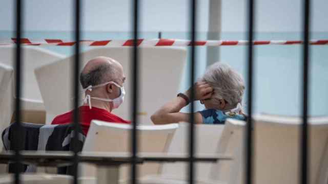 Una pareja con mascarilla en la piscina de un hotel en Tenerife en cuarentena por el coronavirus / EP