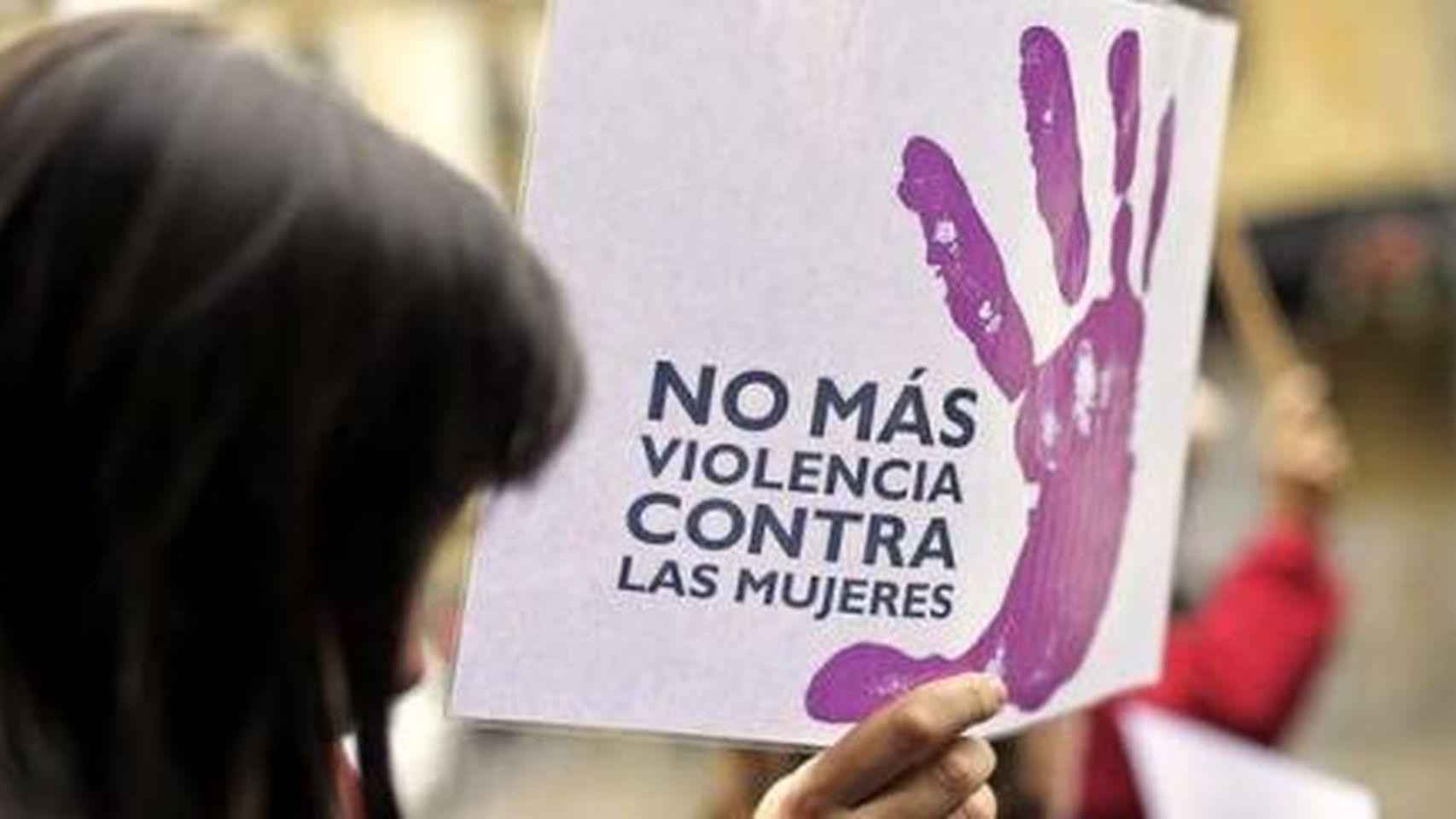 Una mujer sostiene un cartel con el texto No más violencia contra las mujeres