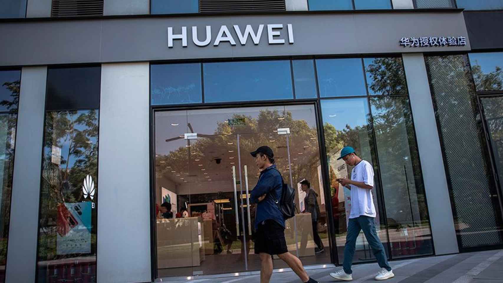 Varias personas caminan frente a una tienda de Huawei, en Pekín (China) / EFE