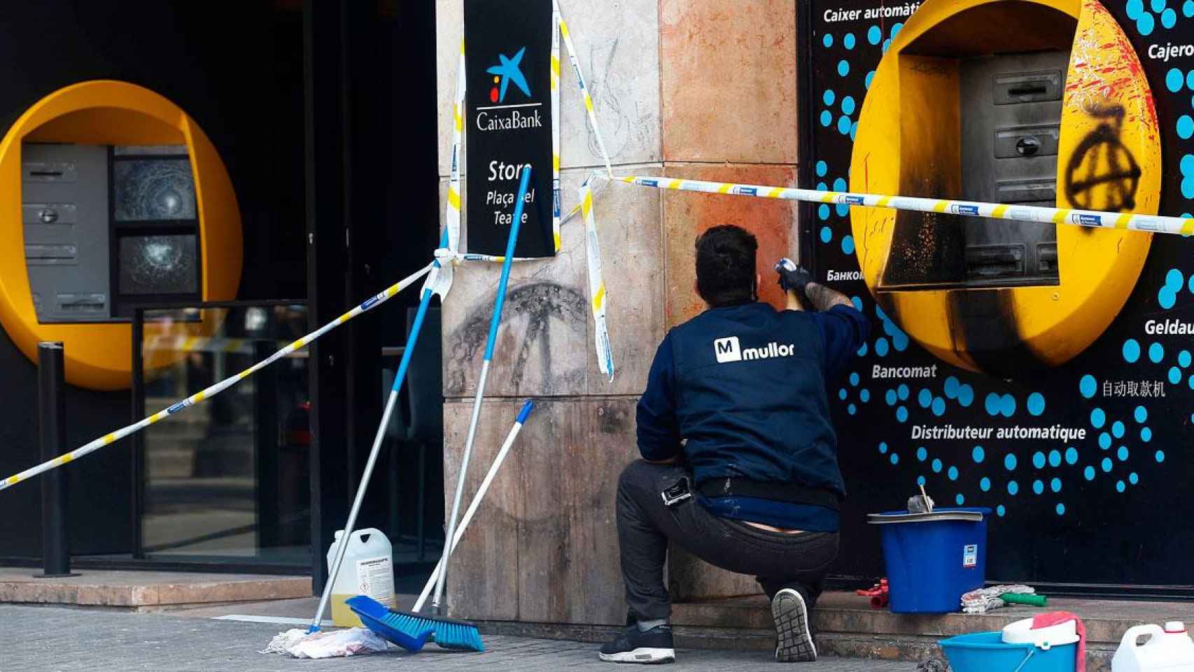 Un operario repara un cajero vandalizado y quemado durante los disturbios por Pablo Hasél / EFE
