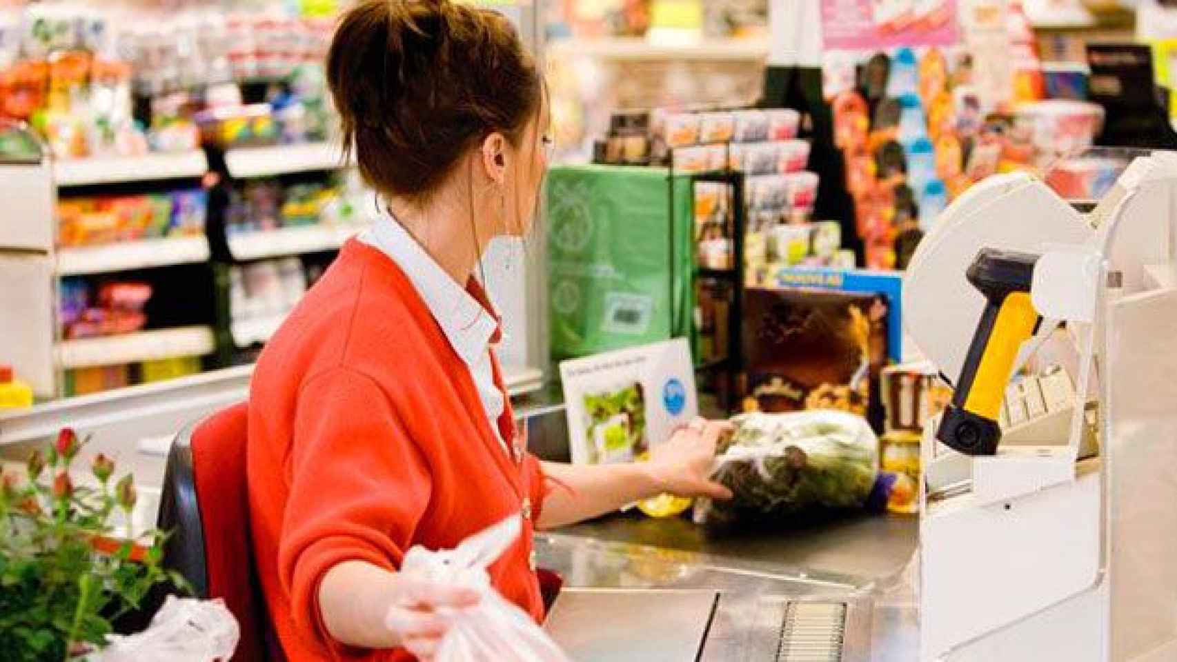 Una mujer trabajando de cajera en un supermercado