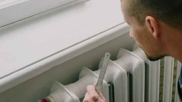 Un chico comprueba el funcionamiento de su calefactor fijo / PEXELS