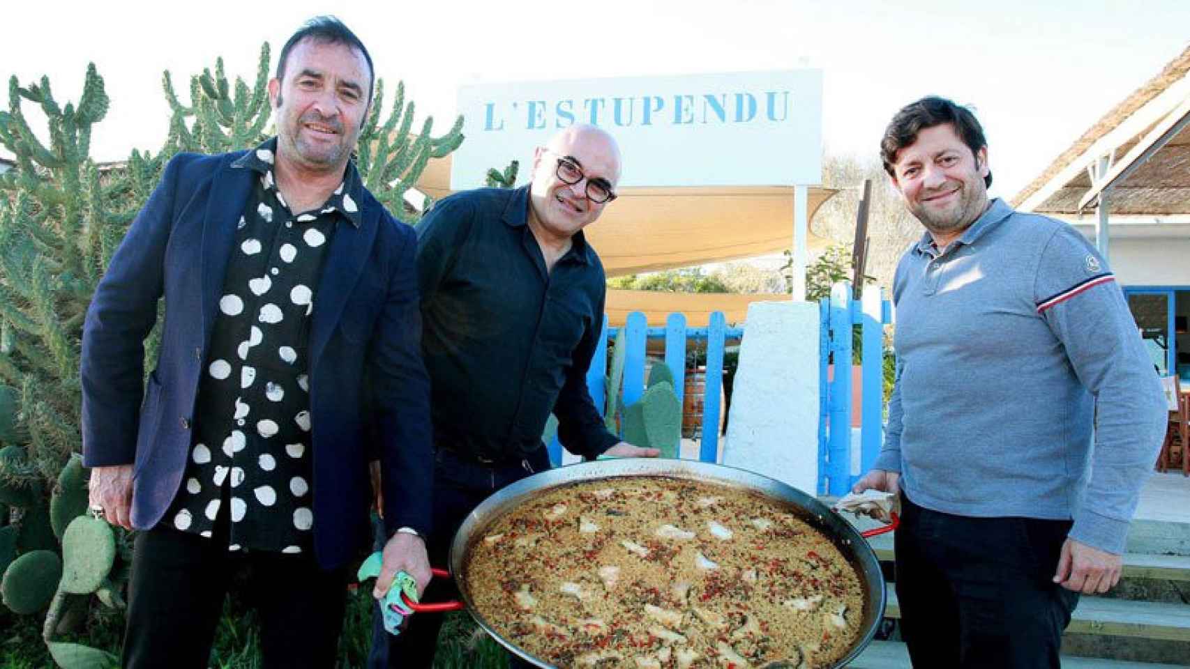 Santi Hoyos, Joan Carles Ninou y José Varela muestran una de las paellas que se sirven en el restaurante L'Estupendu de Badalona