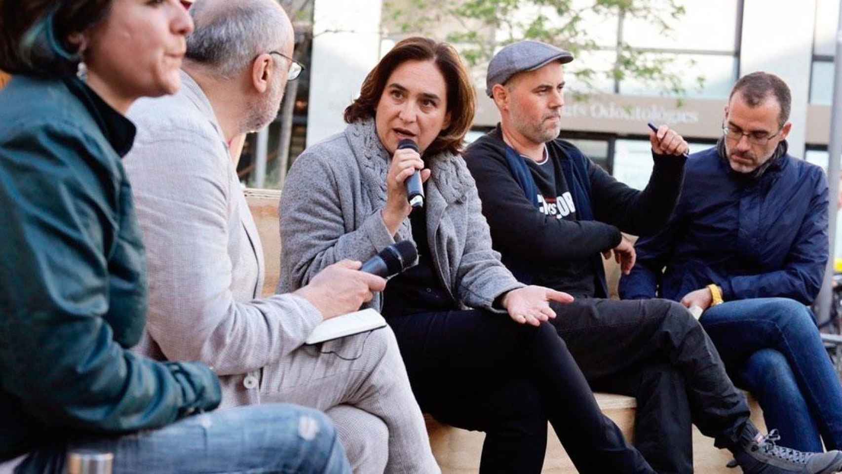 Ada Colau, alcaldesa de Barcelona, con el micrófono, y Eloi Badia, a su izquierda, en un acto político / EP