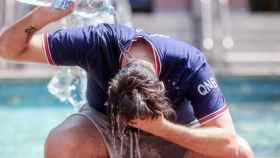 Un joven se tira una botella de agua por encima durante la ola de calor, como la que espera Cataluña este verano, por lo que el Govern adelanta el plan contra las altas temperaturas / EP