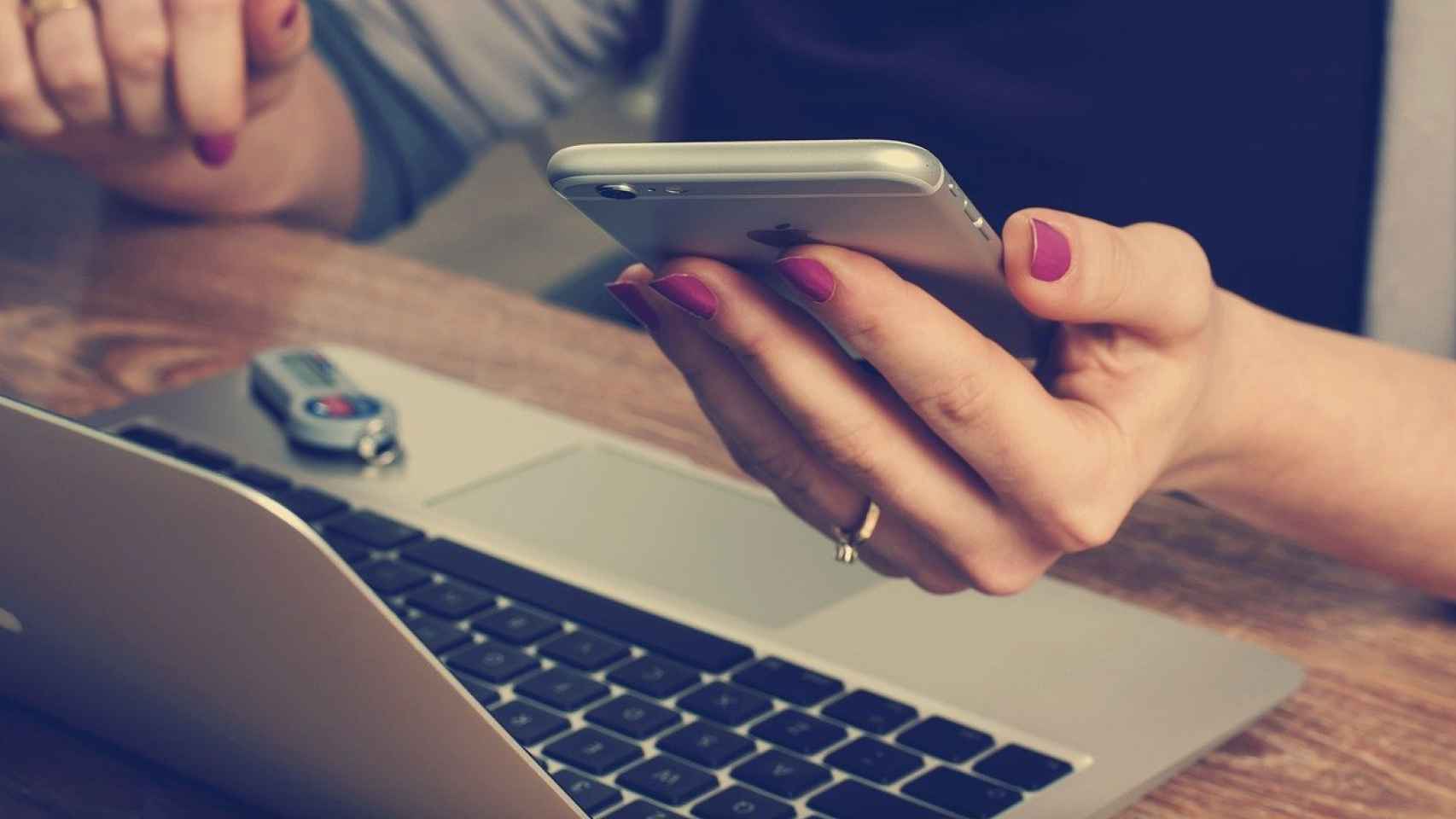 Una mujer consulta su móvil y su ordenador para saber si es víctima de una estafa / PIXABAY