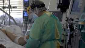 Un sanitario, atendiendo a un paciente en una uci dedicada a enfermos de coronavirus / EUROPA PRESS