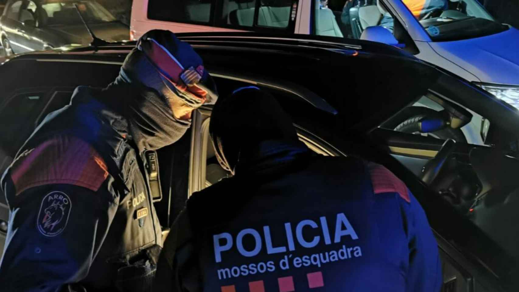 Dos agentes junto a una patrulla de los Mossos d'Esquadra / MOSSOS