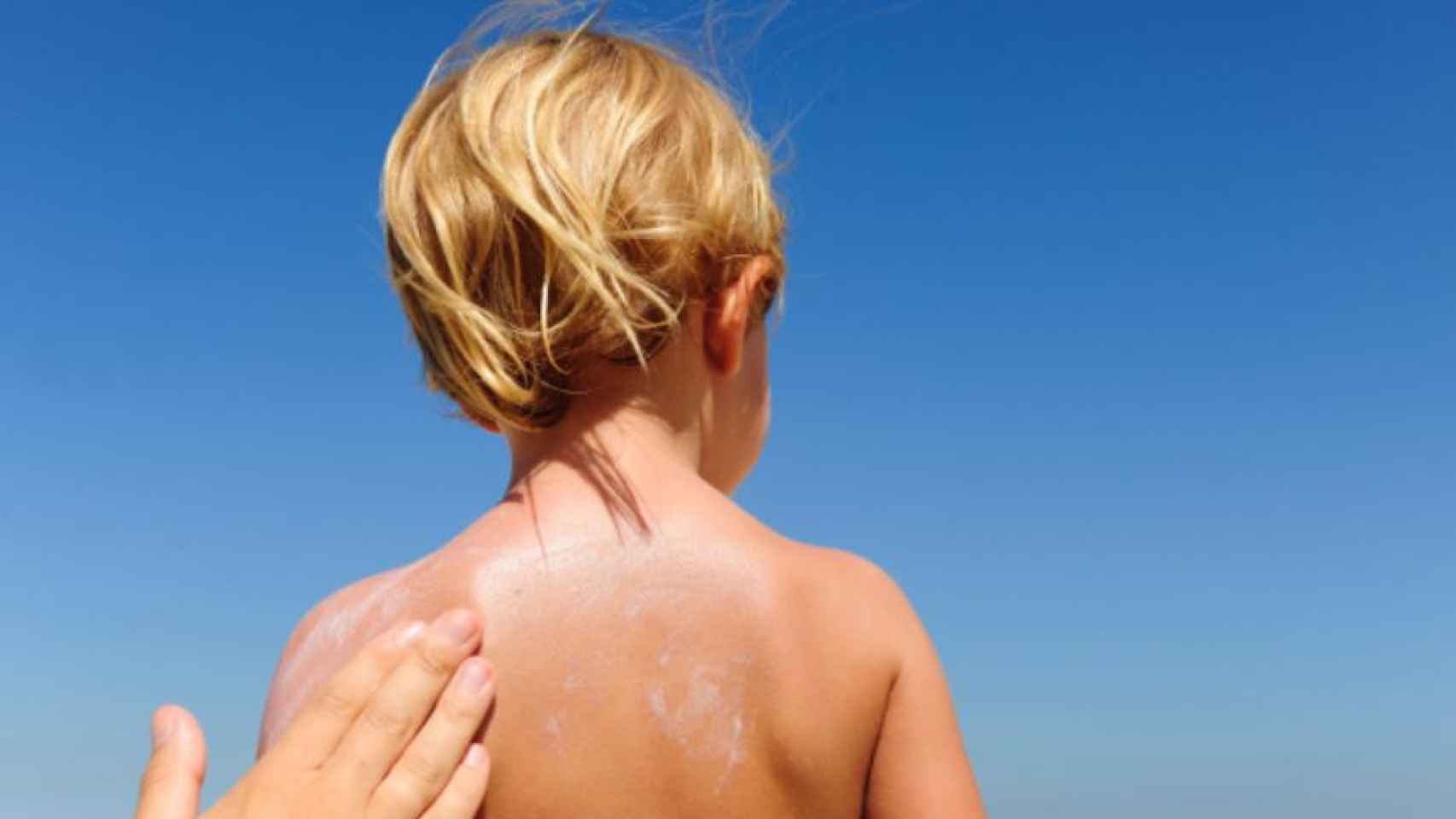 Un adulto aplica una de las mejores cremas solares a un niño