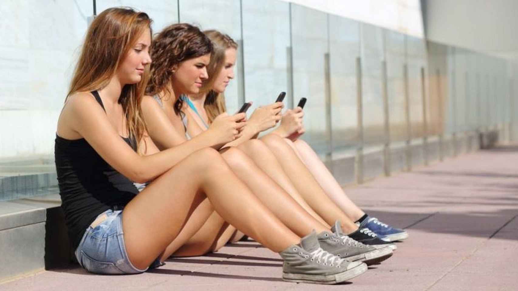 Un grupo de adolescentes mirando el móvil, una adicción que se contempla en el plan contra las drogas de Barcelona / CG