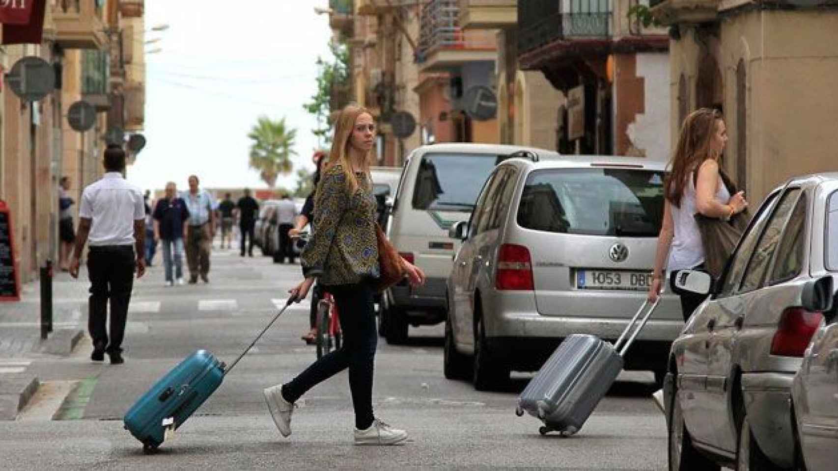 Dos turistas caminan con maletas por el barrio de la Barceloneta / EFE