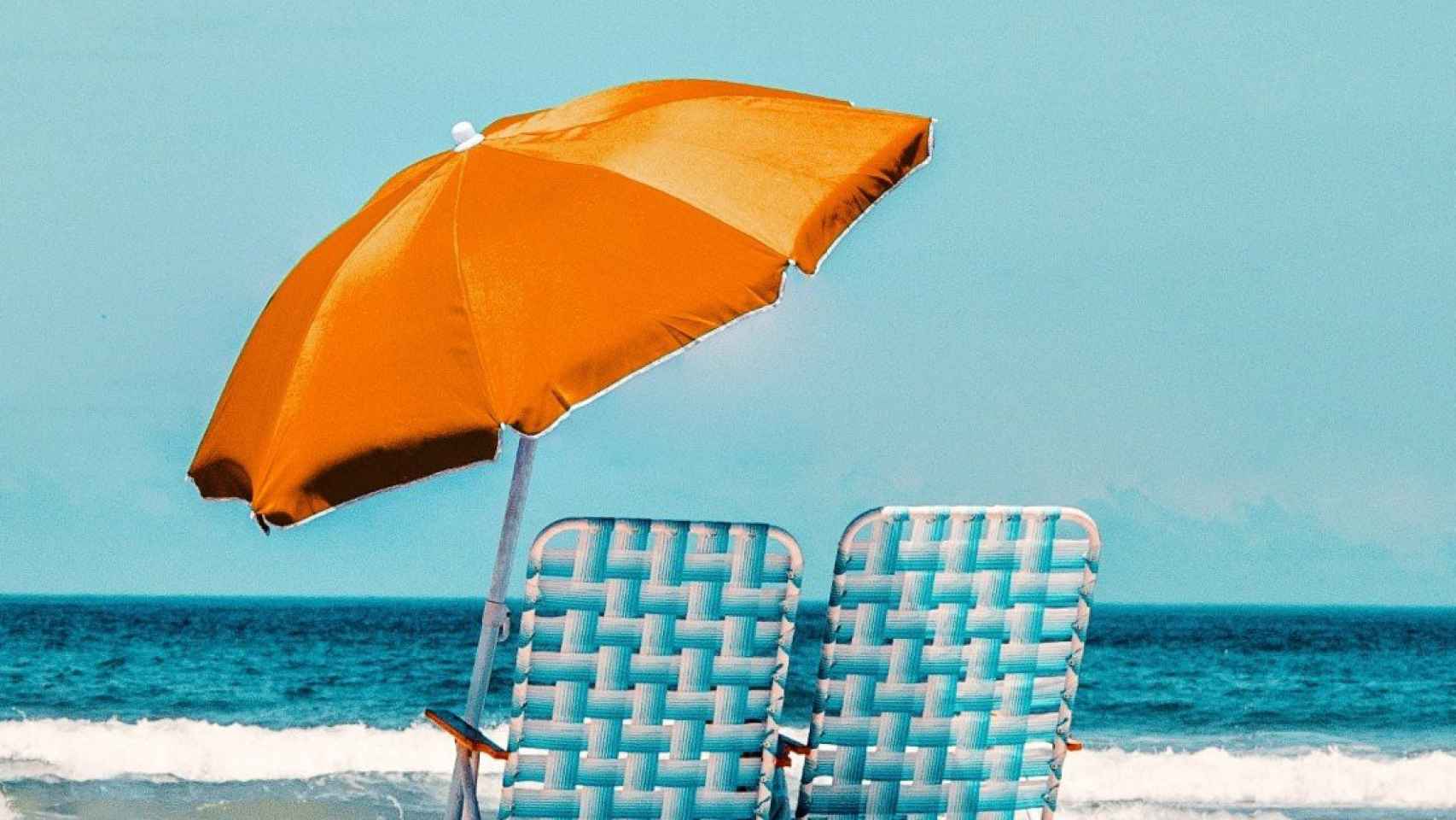 Dos sillas y una sombrilla en la playa