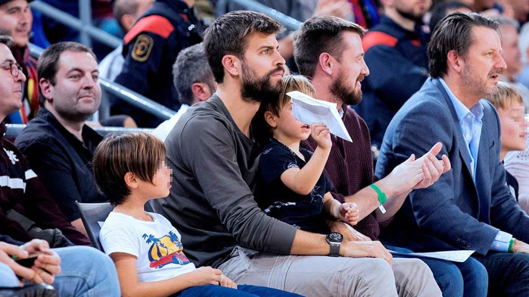 El defensa del FC Barcelona de fútbol Gerard Piqué (c) y sus hijos durante el partido de la Liga ACB de baloncesto entre Barcelona Lassa y Real Madrid / EFE