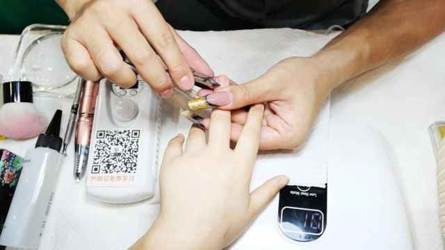 Una manicurista arregla las uñas a una mujer, como las 16 personas que trabajaban sin papeles para un empresario de Girona / EUROPA PRESS