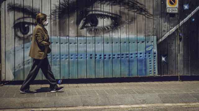 Un ciudadano con mascarilla, caminando por una calle de Barcelona, en Cataluña / EUROPA PRESS
