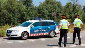 Dos agentes de los Mossos d'Esquadra junto al coche patrulla en una carretera catalana / EP