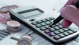 Una calculadora junto a unas monedas y unos presupuestos / EFE