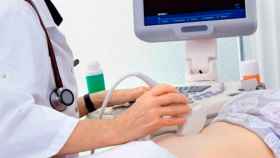 Un ginecólogo haciendo una ecografía a una paciente