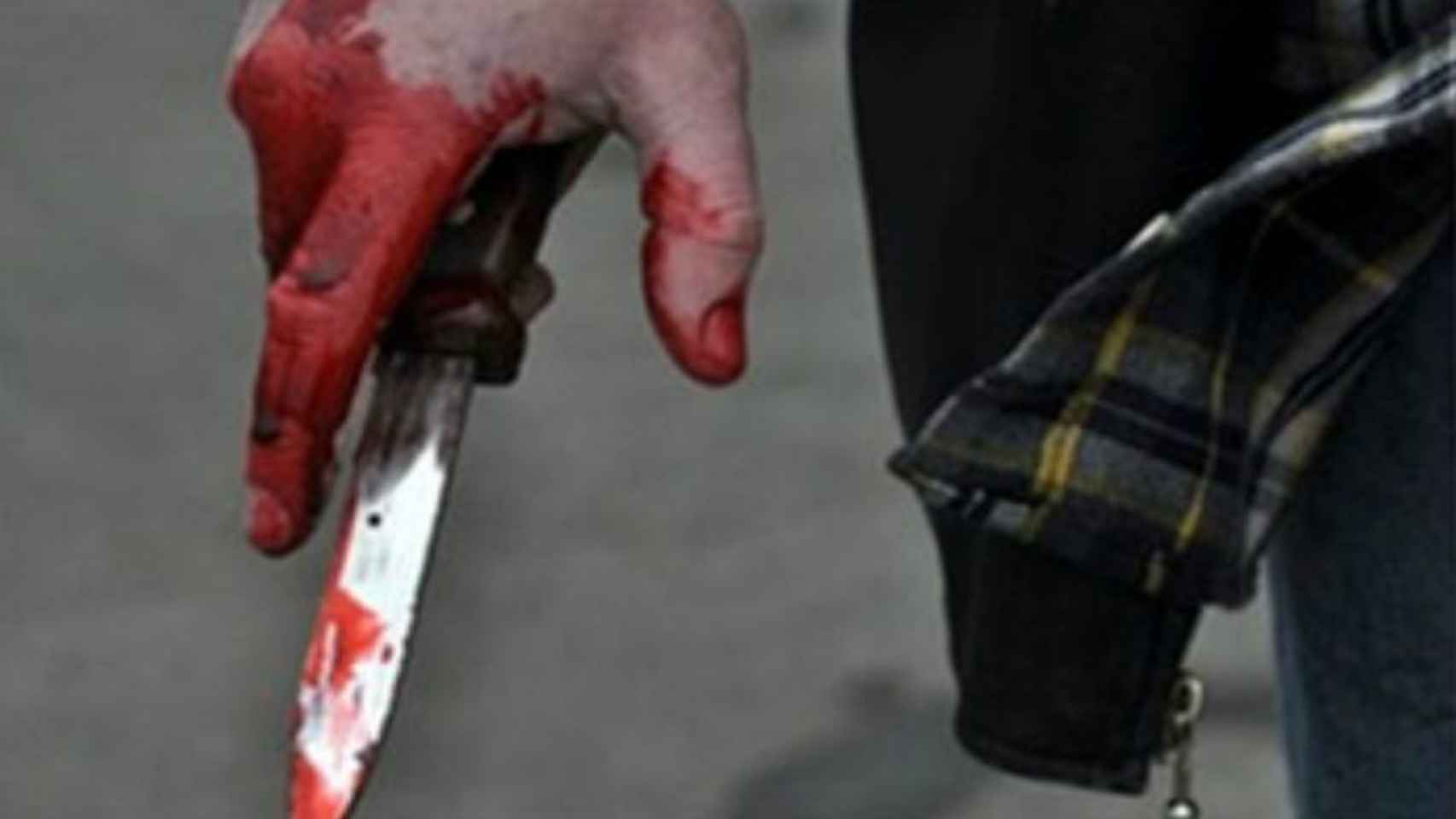 Una foto de un joven aguantando un cuchillo ensangrentado