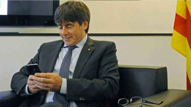 Carles Puigdemont revisa su teléfono móvil / EUROPA PRESS