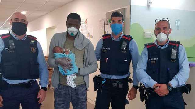 Los tres mossos junto al padre y el bebé al que han salvado la vida / MOSSOS