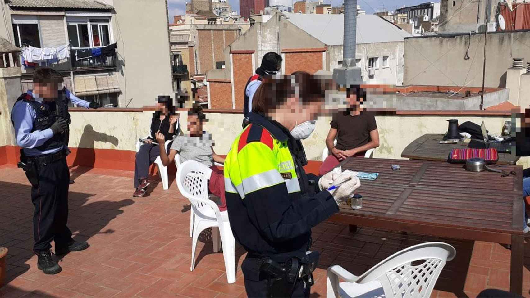 Agentes de mossos durante su actuación en la terraza de una vivienda en Sants / CG