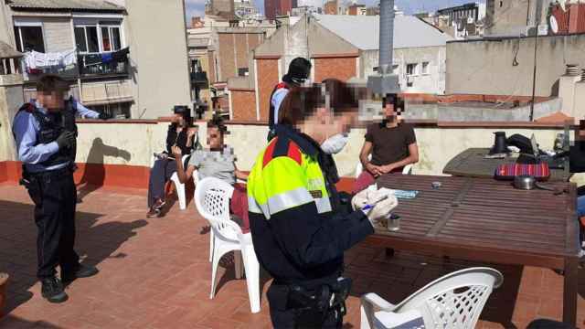 Agentes de mossos durante su actuación en la terraza de una vivienda en Sants / CG