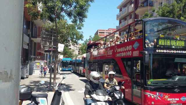 Autobús turístico de dos pisos y, en segundo plano, bus lanzadera azul hacia el Park Güell a su paso por la avenida Virgen de Montserrat de Barcelona / @VeinsdeCanBaro