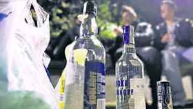 Botellas de alcohol con jóvenes al fondo, en una imagen de archivo / EFE