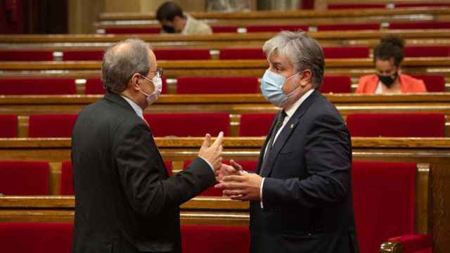 El portavoz de JxCat, Albert Batet (d), conversa con el presidente Quim Torra (i) en el Parlament / EP