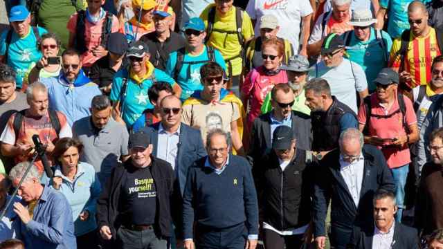 Quim Torra y el exlehendakari Juan José Ibarretxe encabezando una marcha que corta la autopista AP-7. A la izquierda, con el cabello blanco, el jefe de protocolo de la Generalitat / EFE