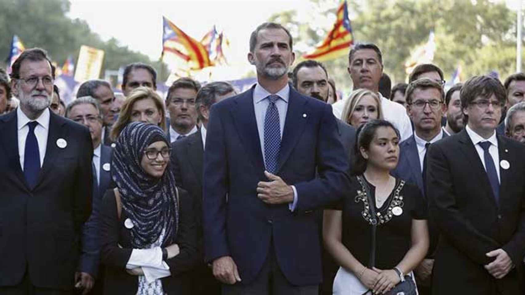 El presidente español Mariano Rajoy, el rey Felipe VI y el presidente catalán Carles Puigdemont, en la cabecera de la manifestación contra el terrorismo, con banderas independentistas al fondo  / EFE