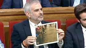 El portavoz de Ciudadanos, Carlos Carrizosa, muestra una foto de niños de la cola en el Parlamento catalán / CG