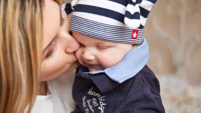Una mujer le da un beso a su niño / PXHERE