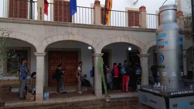 Los voluntarios llegaban a primera hora de esta mañana a Sant Llorenç y hacían cola en el Ayuntamiento para inscribirse / EFE