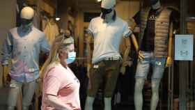 Una mujer pasa frente a un comercio de moda, que ha mermado sus ingresos durante la pandemia / EUROPA PRESS