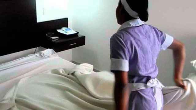 Una camarera de piso hace una cama en un hotel