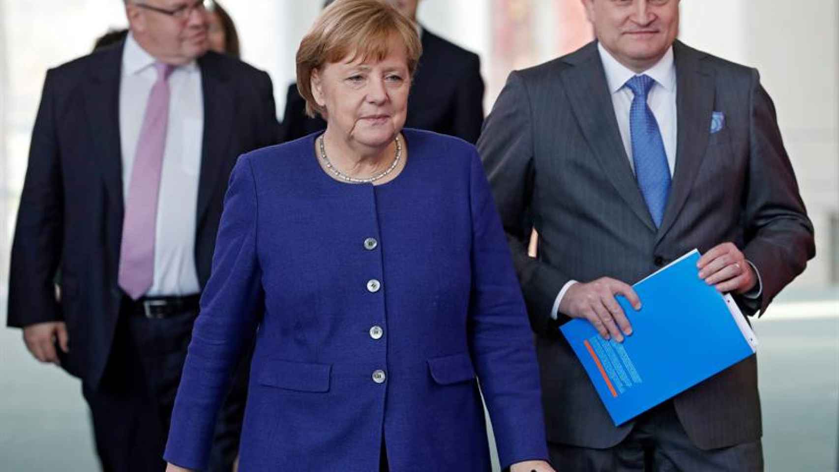 La canciller alemana, Angela Merkel, acompañada por el presidente del Consejo de Expertos, Christoph Schmidt, se dirige a presentar el informe de desarrollo económico / EFE